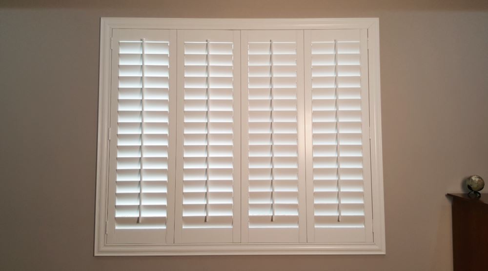 Custom window treatments have a clean fit and a more sophisticated look. Interior custom shutters in a bedroom