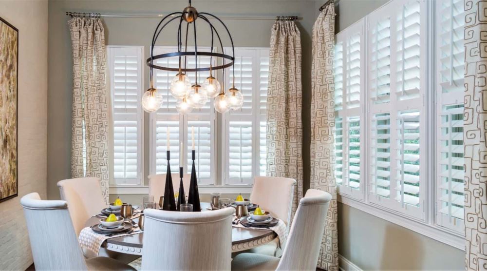 Plantation shutters in a rental property are easy to clean after guests leave. Plantation shutters in a living room.