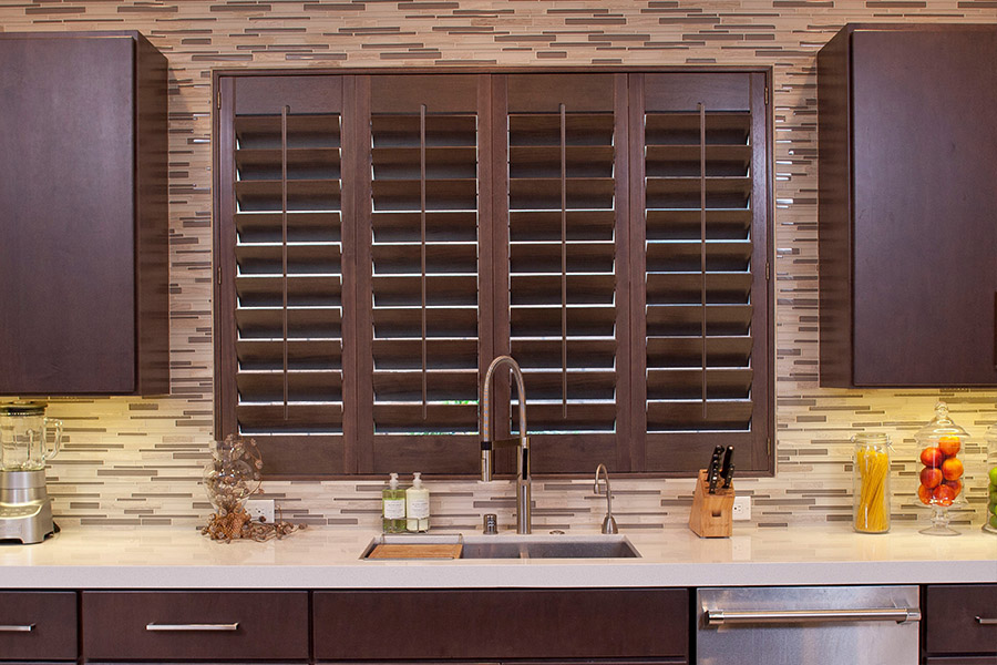 Ask your Sunburst Shutters consultant to help you pick the best shutter frame for your windows. Dark wood Ovation shutters above a kitchen sink.