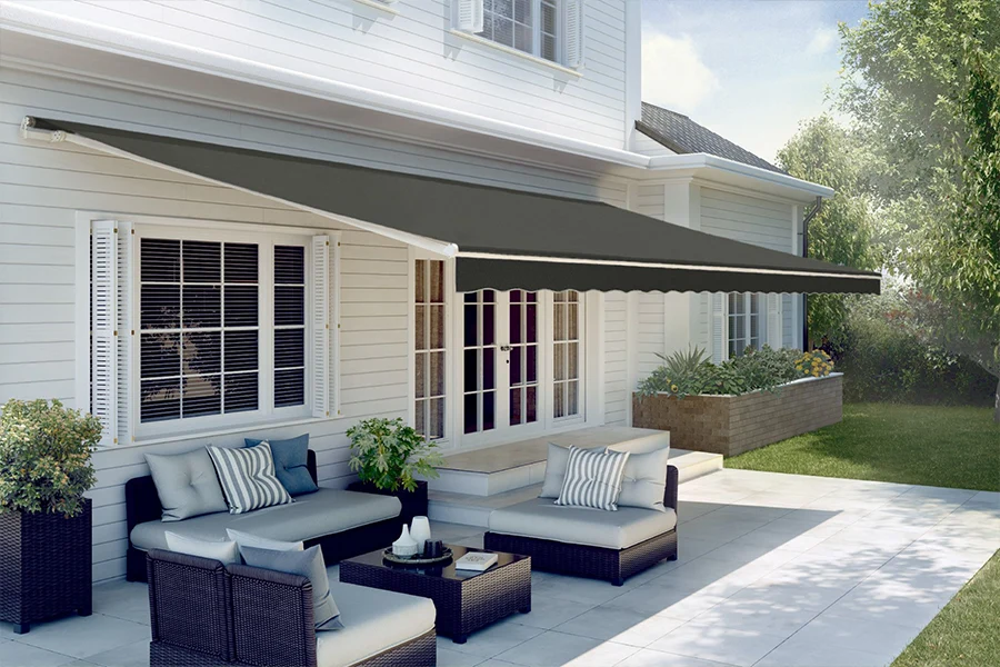 Enjoy cool shade in seconds with a state-of-the-art motorized awning. A gray retractable awning over a large patio