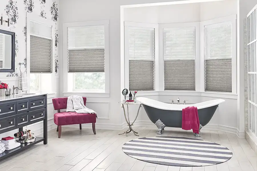 Dark gray cellular shades within a bay window area inside a modern like bathroom