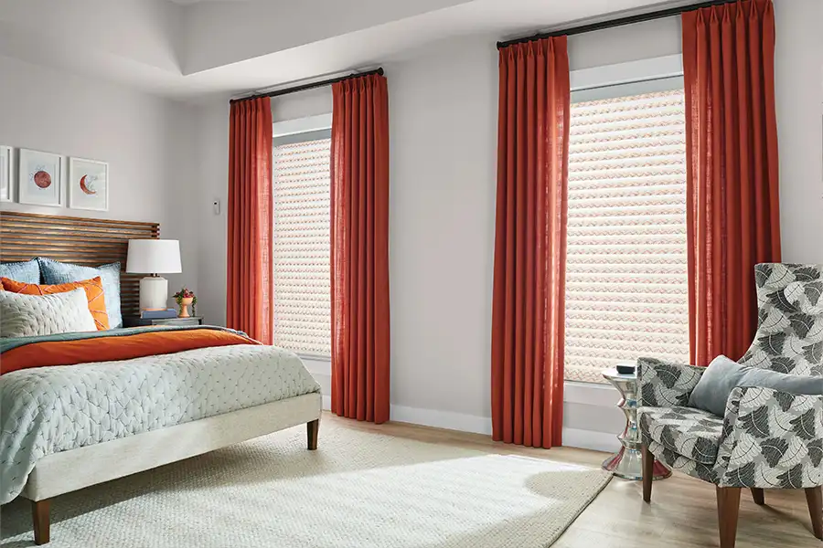 Orange drapes on windows in a beige bedroom