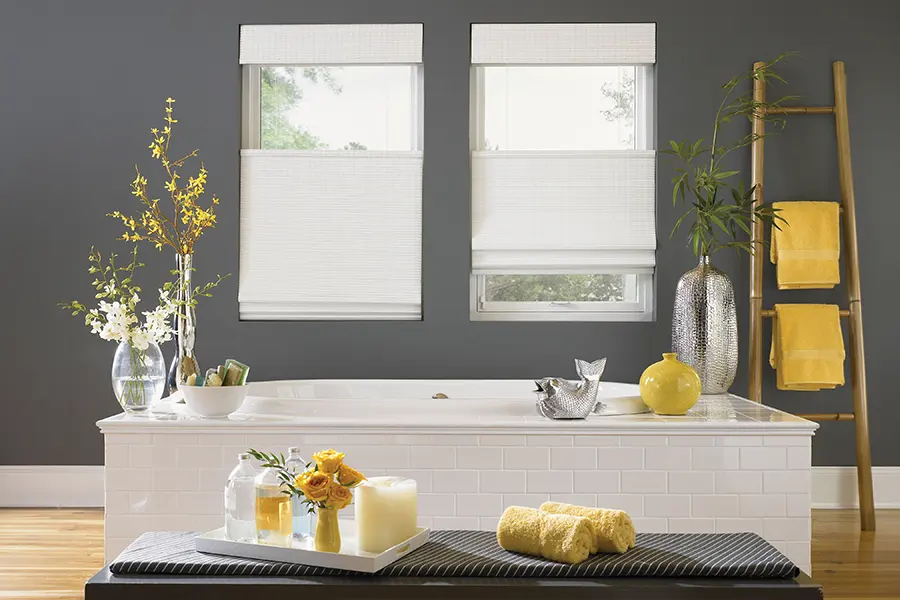 Ask your window treatment consultant about how their top-down/bottom-up shades work. White Roman top-down/bottom-up shades lowered from the top on bathroom windows