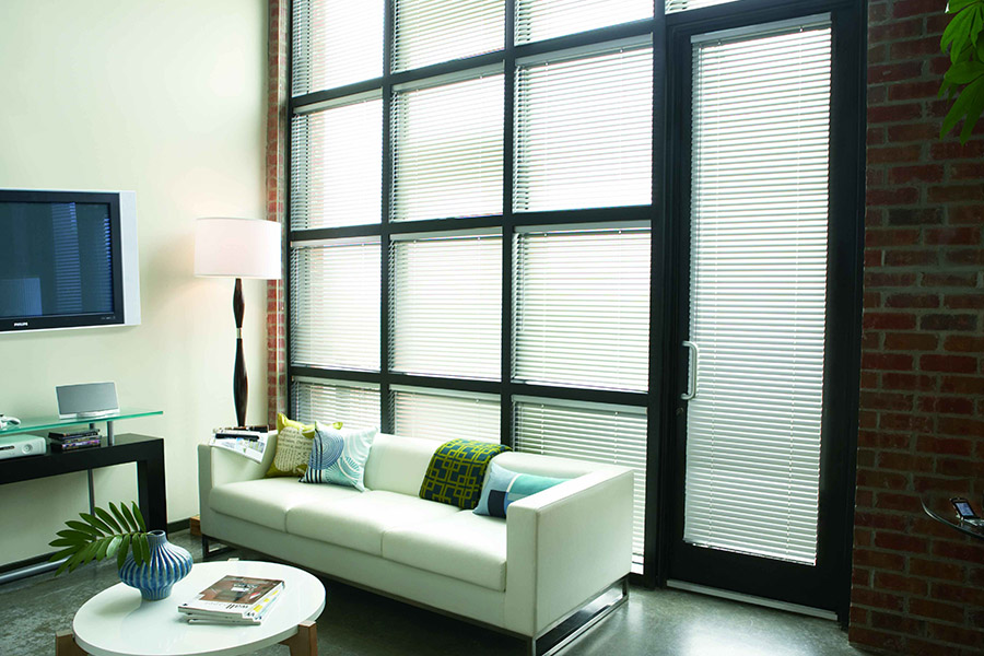 White window blinds brighten up dark decor.  White blinds on black living room windows