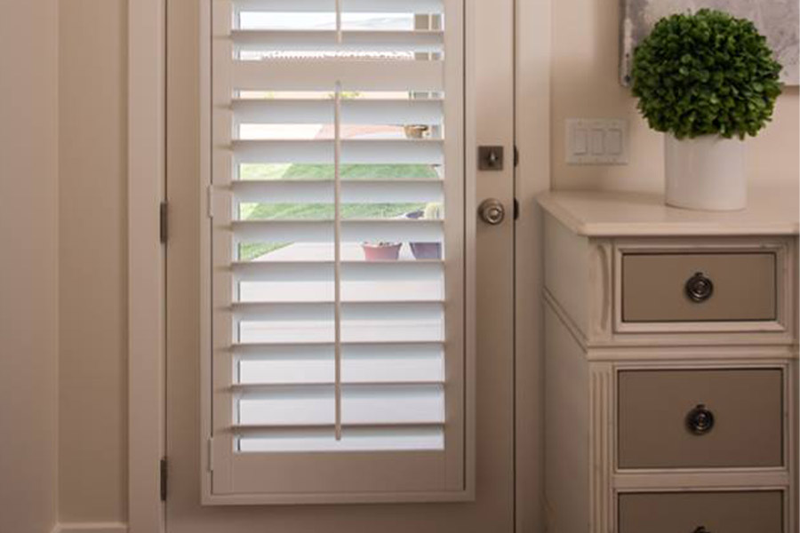 Brighten up your mudroom with white Polywood shutters. White Polywood shutters on a door