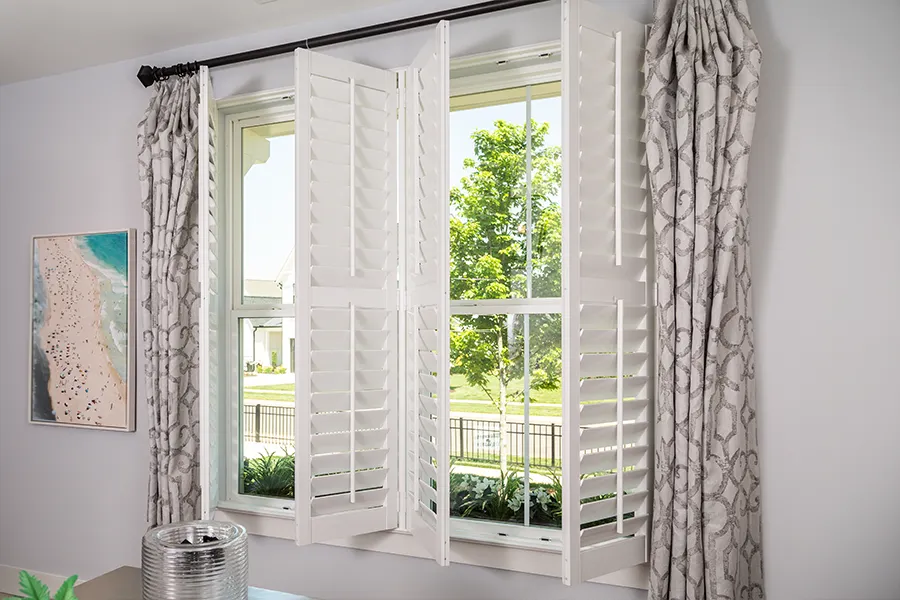 white polywood shutters opened on a beautiful sunny day in a living room area