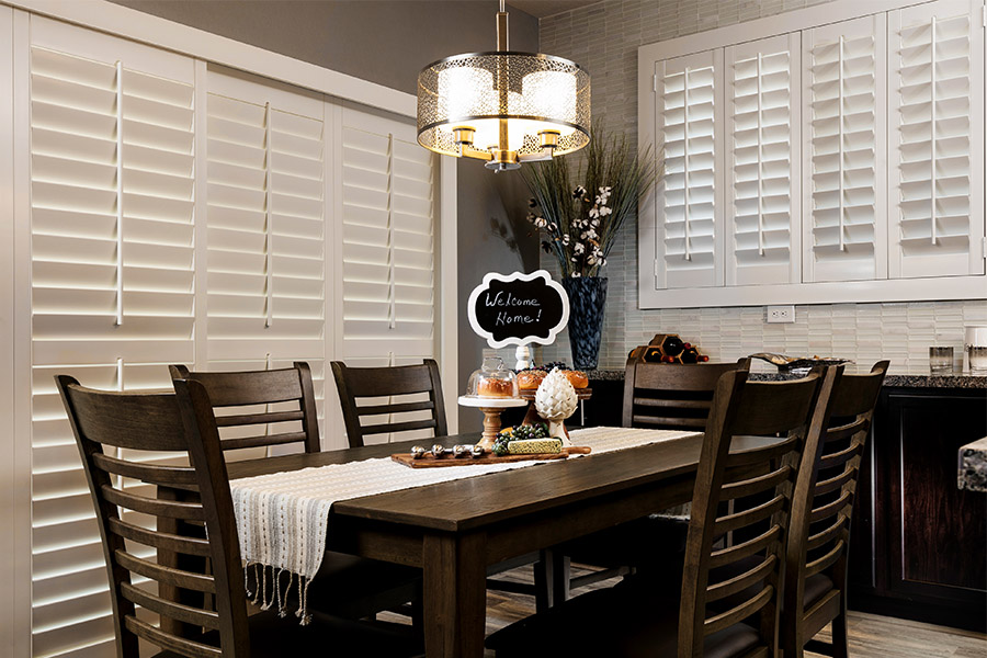White Polywood shutters look beautiful with all types of home decor. White Polywood shutters on a sliding door in a stylish dining room