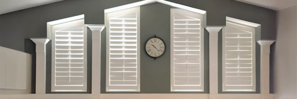 White Polywood shutters on rake windows in a living room