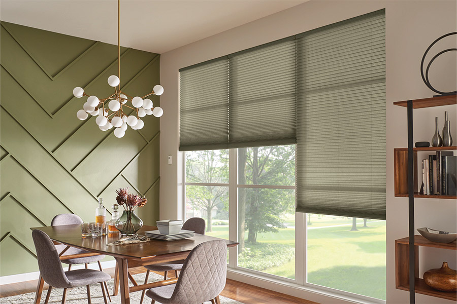 Don't settle for subpar shades. Quality shades offer privacy, light control, energy efficiency, and style. Green cellular shades in a green dining room