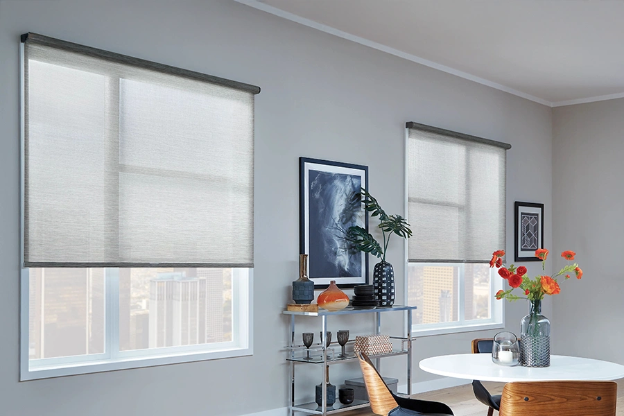 Navy blue solar shades layered with gray roller shades on bedroom windows
