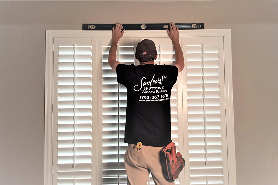 Now that you know all about window treatments, get the best ones for your home from Sunburst Shutters! A Sunburst Shutters employee installing Polywood shutters in a home