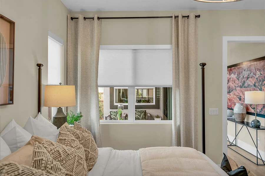 Drapes and a shade on a bedroom window