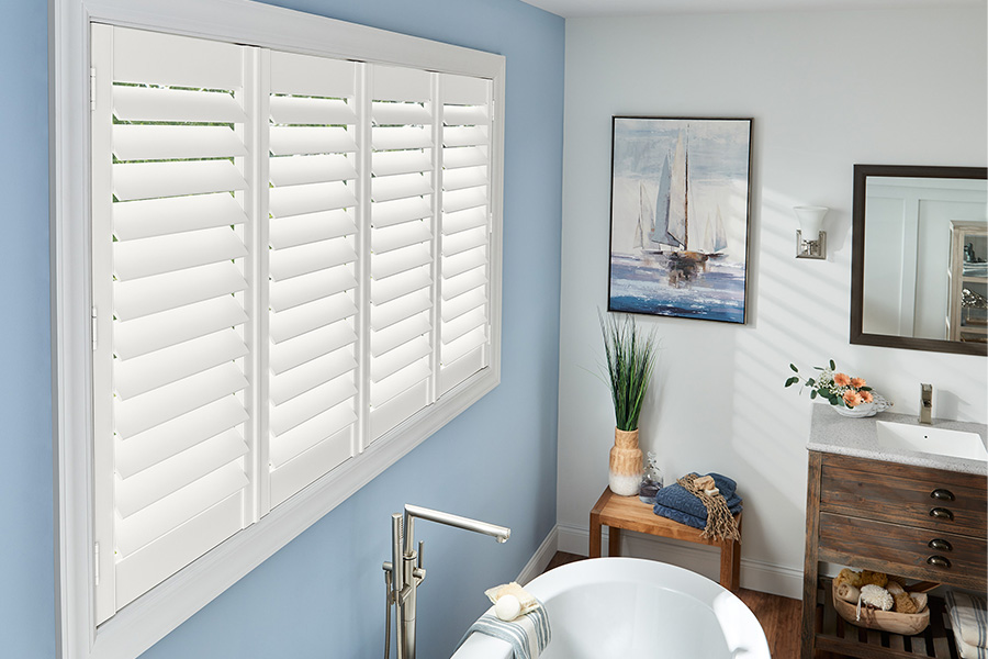 Only beautiful Polywood shutters last decades in wet bathrooms. White polywood shutters above a white tub