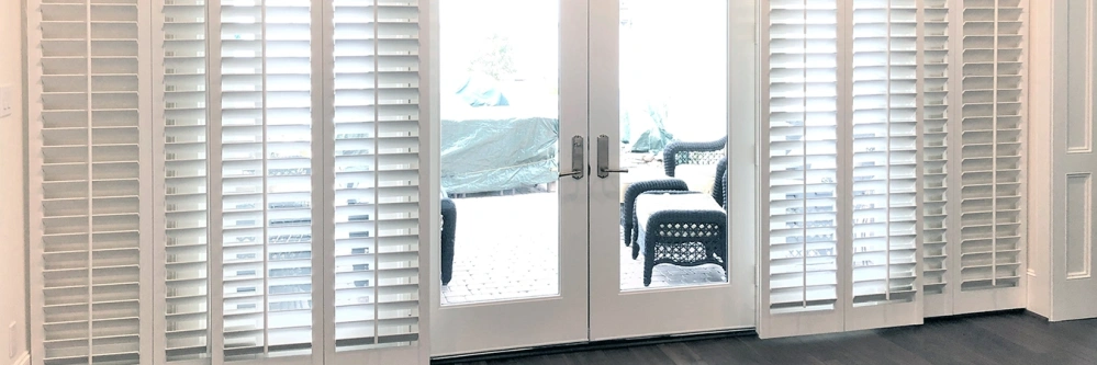 White sliding Polywood shutters on a patio door